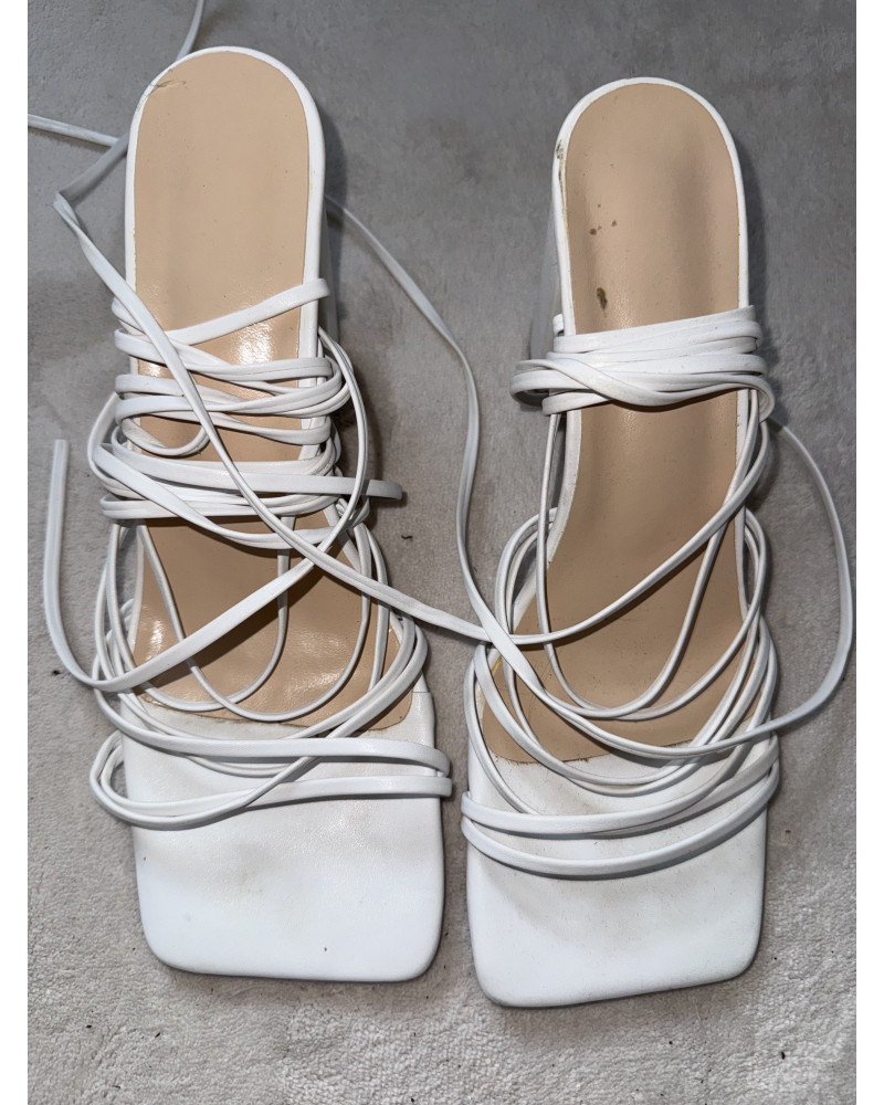 Moderne weiße Highheels mit langen Wickelriemen.